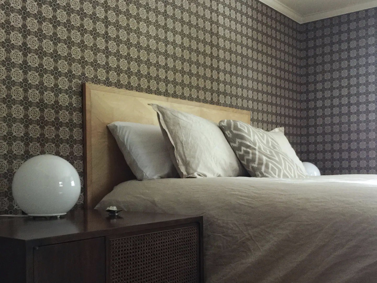 visite deco appartement mid century modern tête de lit cuir beige lampe de chevet globe en verre blanc table de nuit chambre vintage épurée