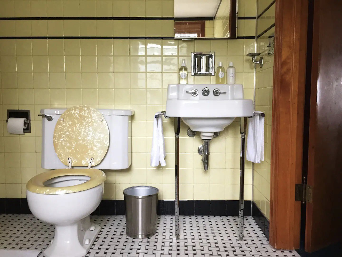 visite deco appartement mid century modern salle de bain vintage jaune pastel noir blanc sol sanitaire d'époque faïence blanche chromé