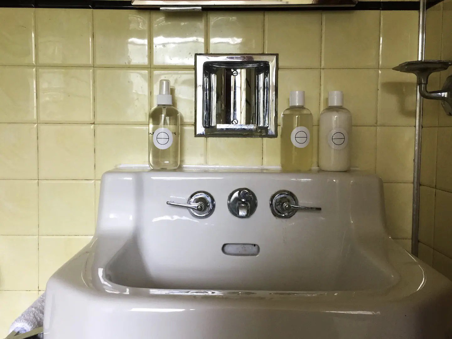 visite deco appartement mid century modern détail lavabo blanc en faïence vintage carrelage jaune pastel carré chic et rétro