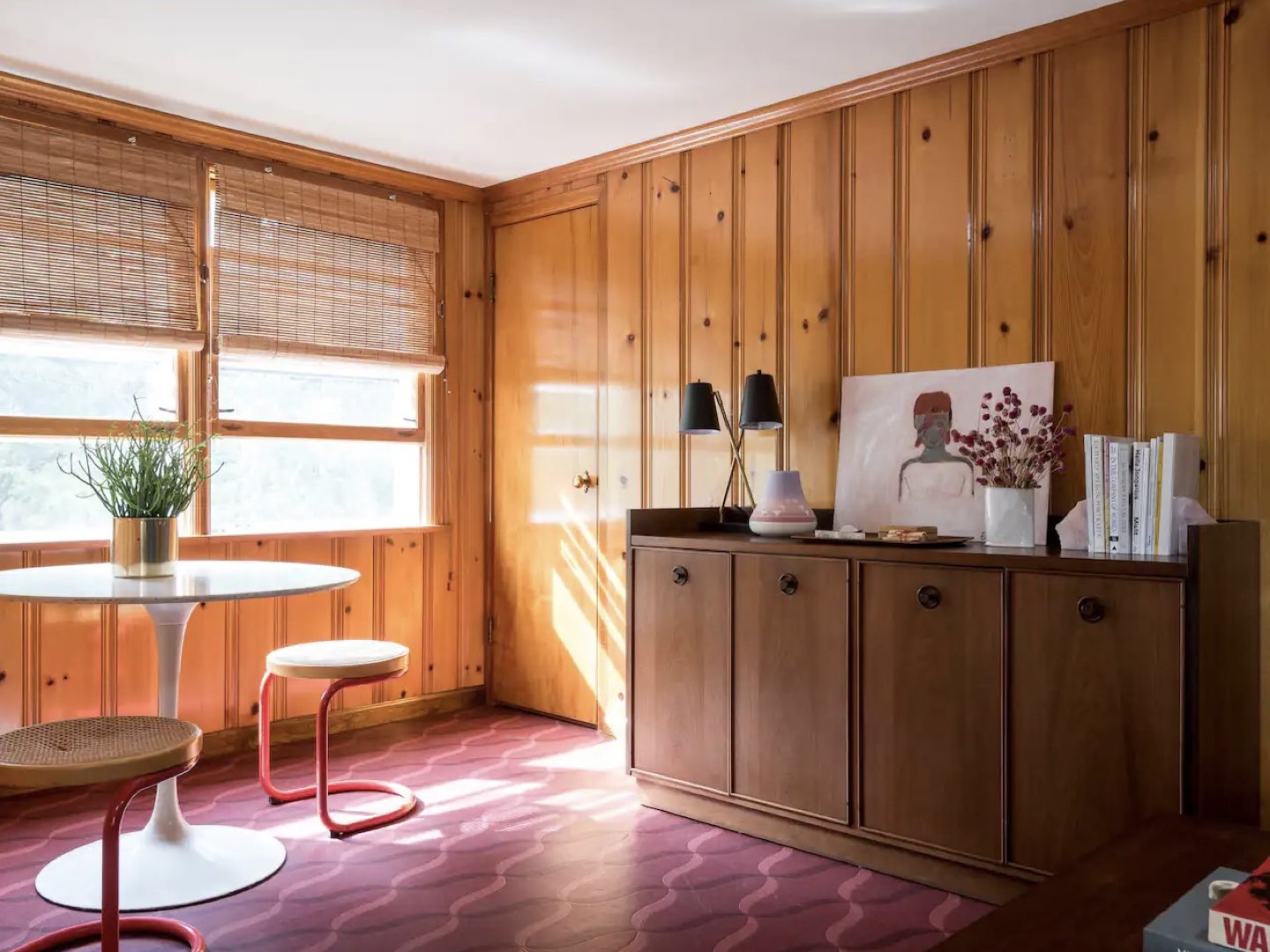 visite deco appartement mid century modern salle de séjour lumineuse bois foncé buffet vintage table ronde design tulipe blanche tabouret piètement métal