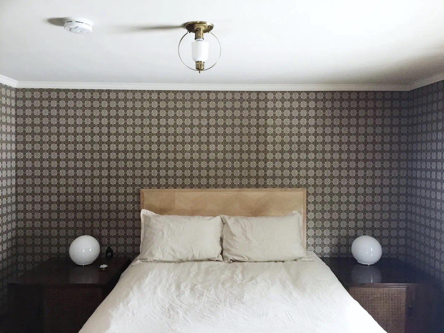 visite deco appartement mid century modern chambre à coucher adulte papier peint imprimé gris tête de lit minimaliste couleur beige lampe de chevet globe en verre opaline