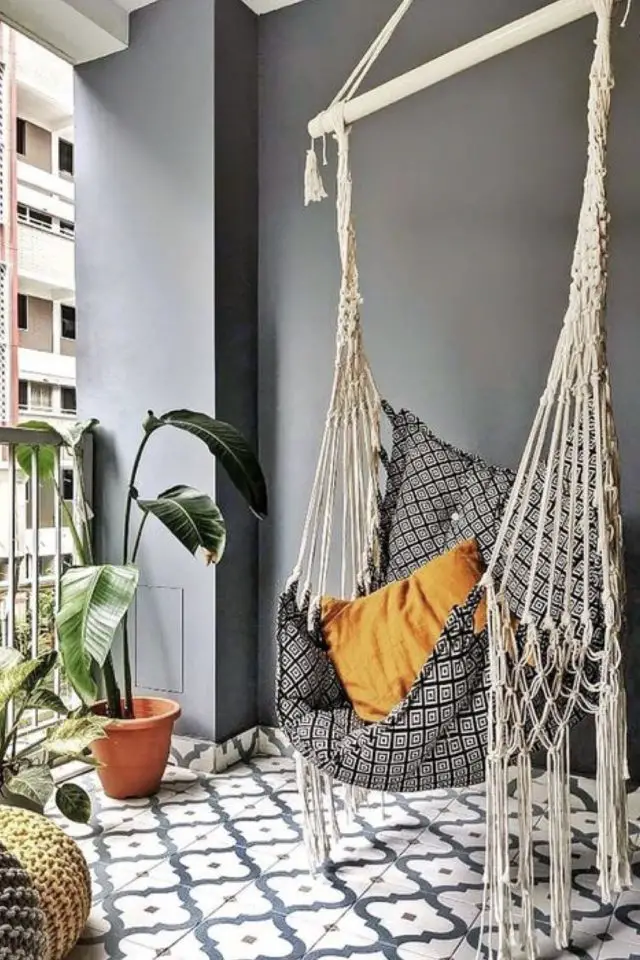 balcon deco moderne confortable fauteuil suspendu coussin plantes vertes revêtement sol coloré