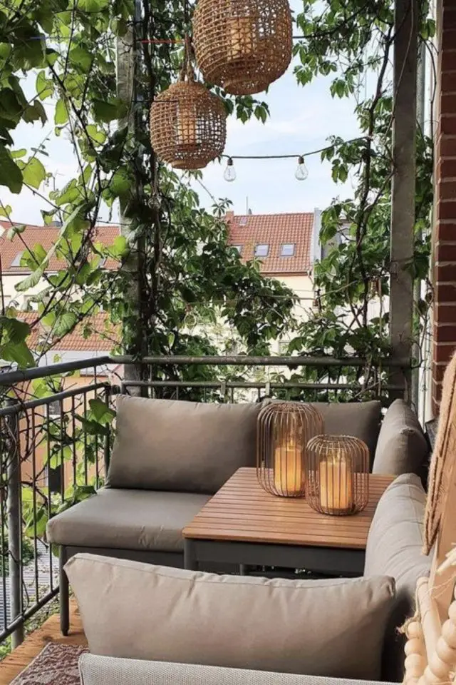 balcon deco moderne confortable banquette coussin table en bois plantes vertes luminaires lanterne