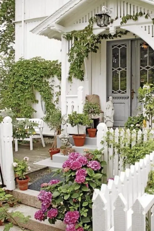 decor jardin devant maison exemple cottage maison blanche clôture en bois petits pots de fleurs en terre cuite bégonias rose plantes grimpantes vignes