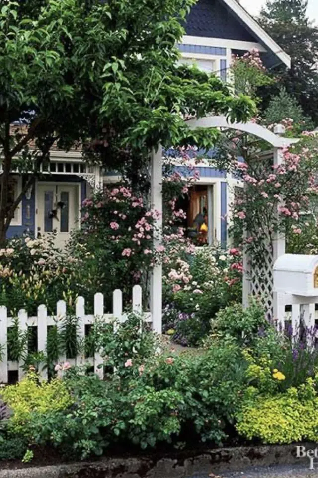 decor jardin devant maison exemple verdoyant plantes fleurs clôture blanche arche en harmonie avec la rue