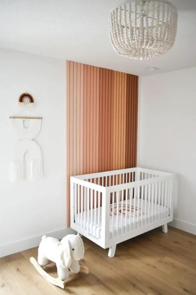 chambre enfant decoration mur bois moderne bébé mis en valeur du lit à barreaux tasseaux de bois peint plusieurs nuances de roses, beige et marron ambiance tendance facile à copier