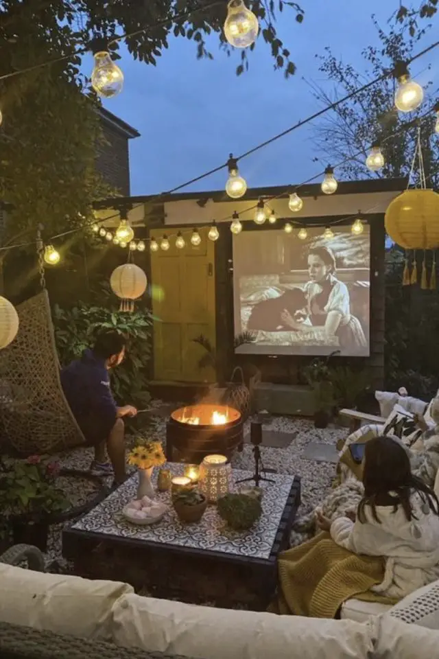 amenagement deco petit patio exterieur espace cinéma en plein air canapé de jardin table basse guirlande lumineuse brasero espace convivial et familial