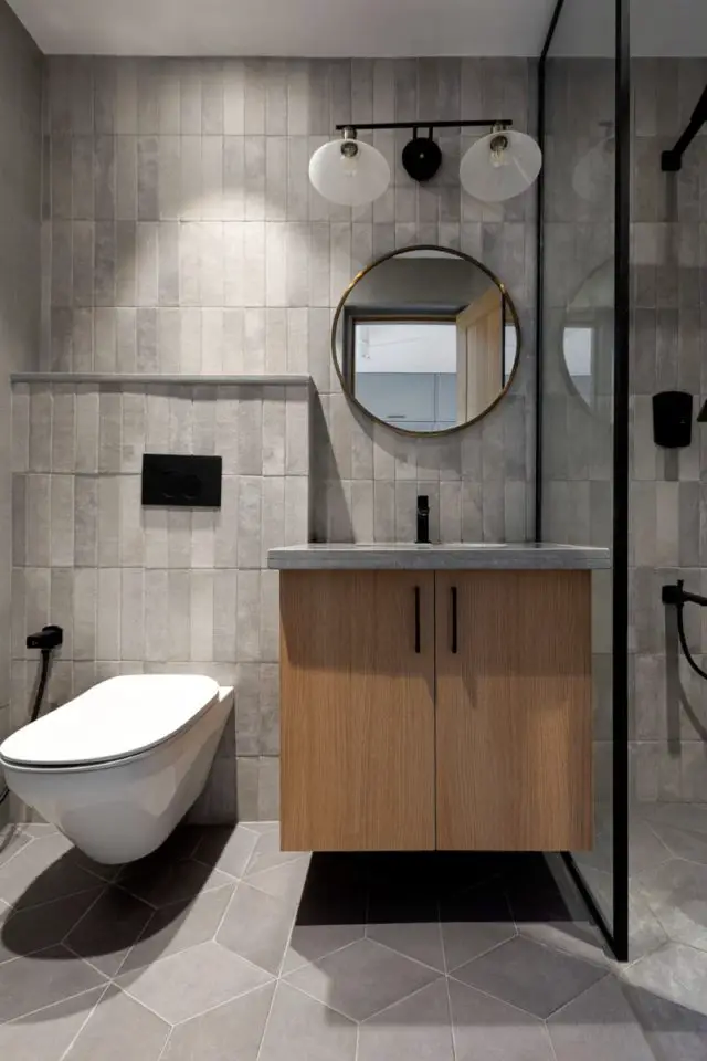appartement chic et slow deco visite salle de bain gris matériaux élégant ton sur ton différent format meuble vasque en bois miroir rond douche