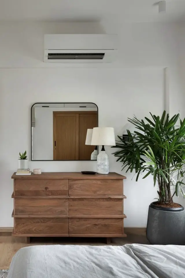 appartement chic et slow deco visite commode en bois avec miroir arrondi plante verte lampe à poser détails décoratifs chambre à coucher