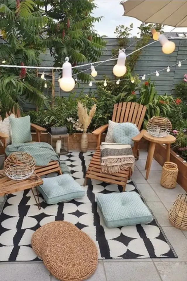 deco patio terrasse convivial meuble en bois décor nature tapis noir et blanc outdoor guirlande lumineuse couleur vert