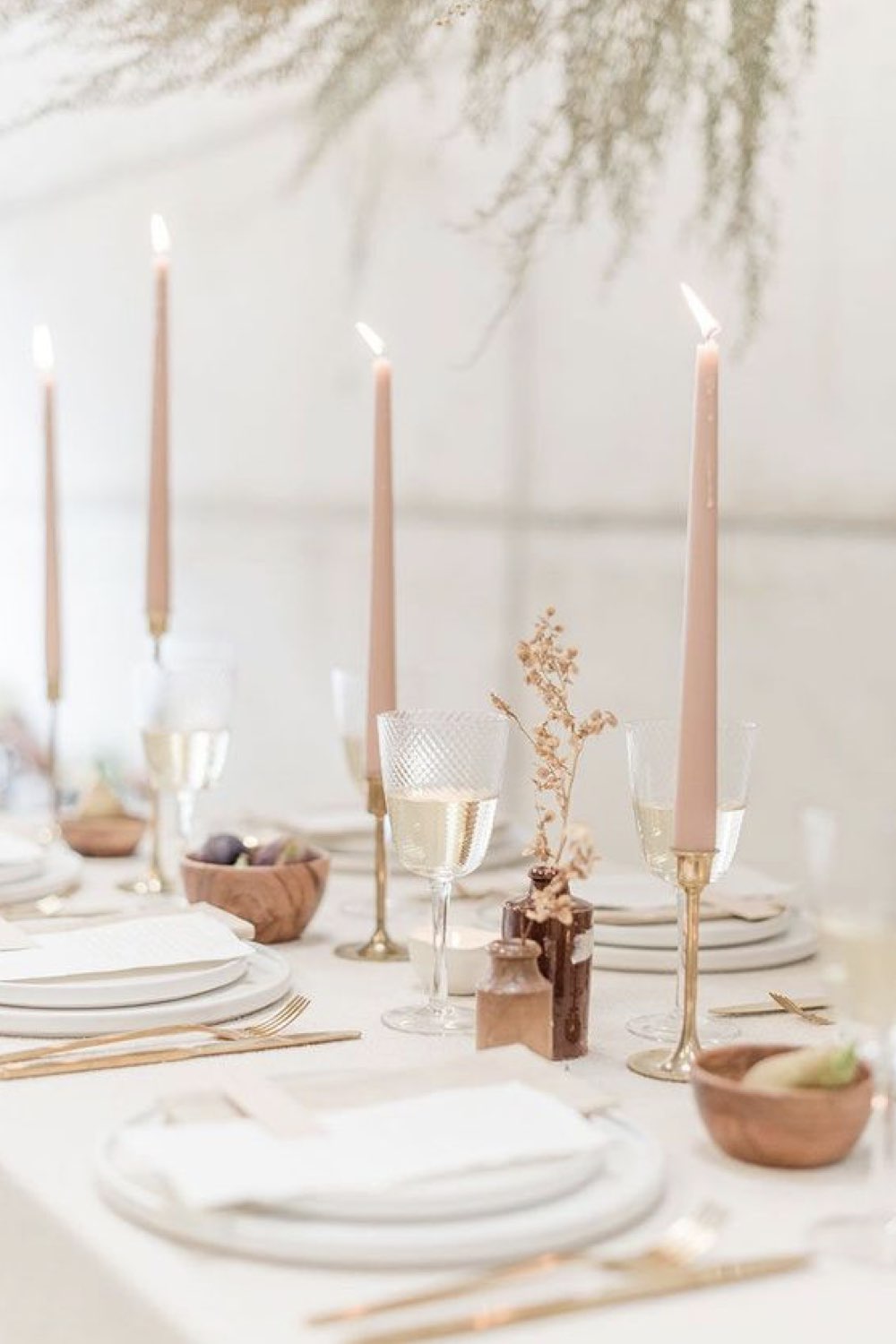 decoration mariage simple minimal chic table décorée élégamment bougie rose pastel assiette blanche  petit vase pour fleur verre à vin en verre relief