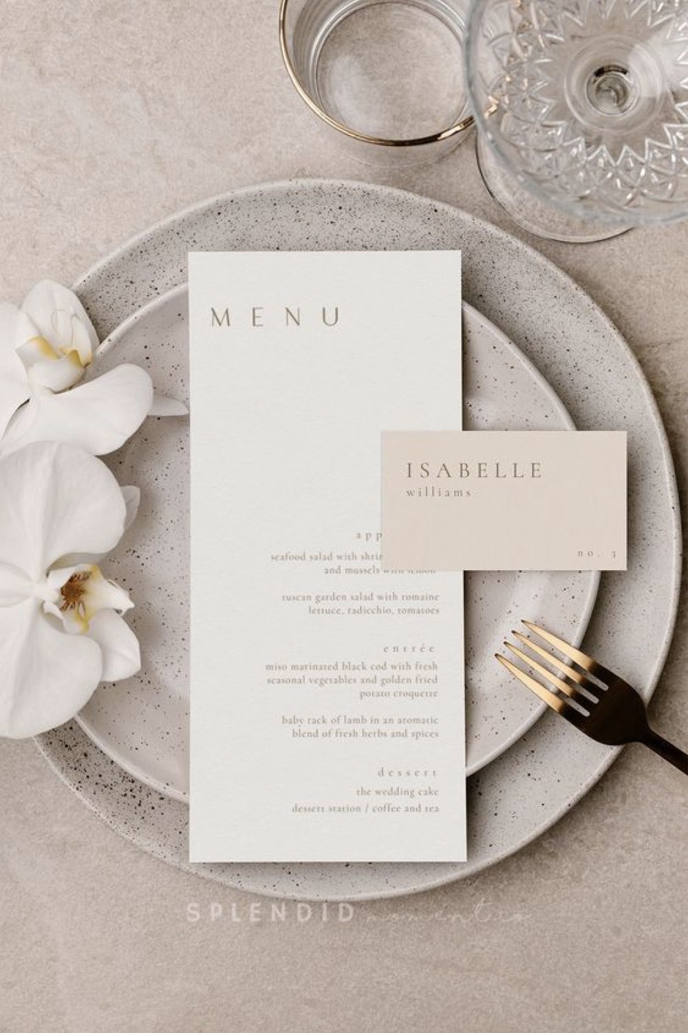decoration mariage simple minimal chic menu et faire-part posé dans l'assiette orchidée blanche élégante couverts dorés verre à pied transparent