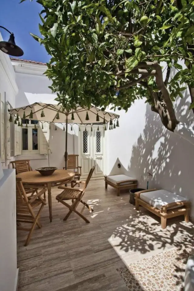 decoration patio a copier mur blanc lumière chaleur arbre parasol beige table ronde en bois 2 personnes