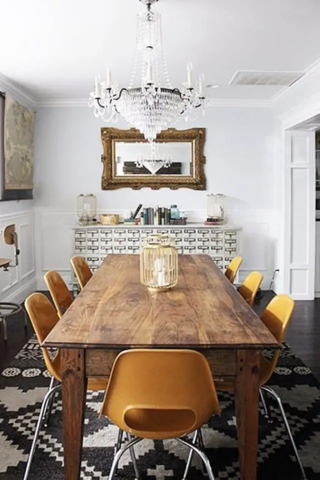 interieur vintage caracteristique decor grande salle à manger blanche table 8 personnes en bois chaises rétro en plastique orange mélange de style éclectisme