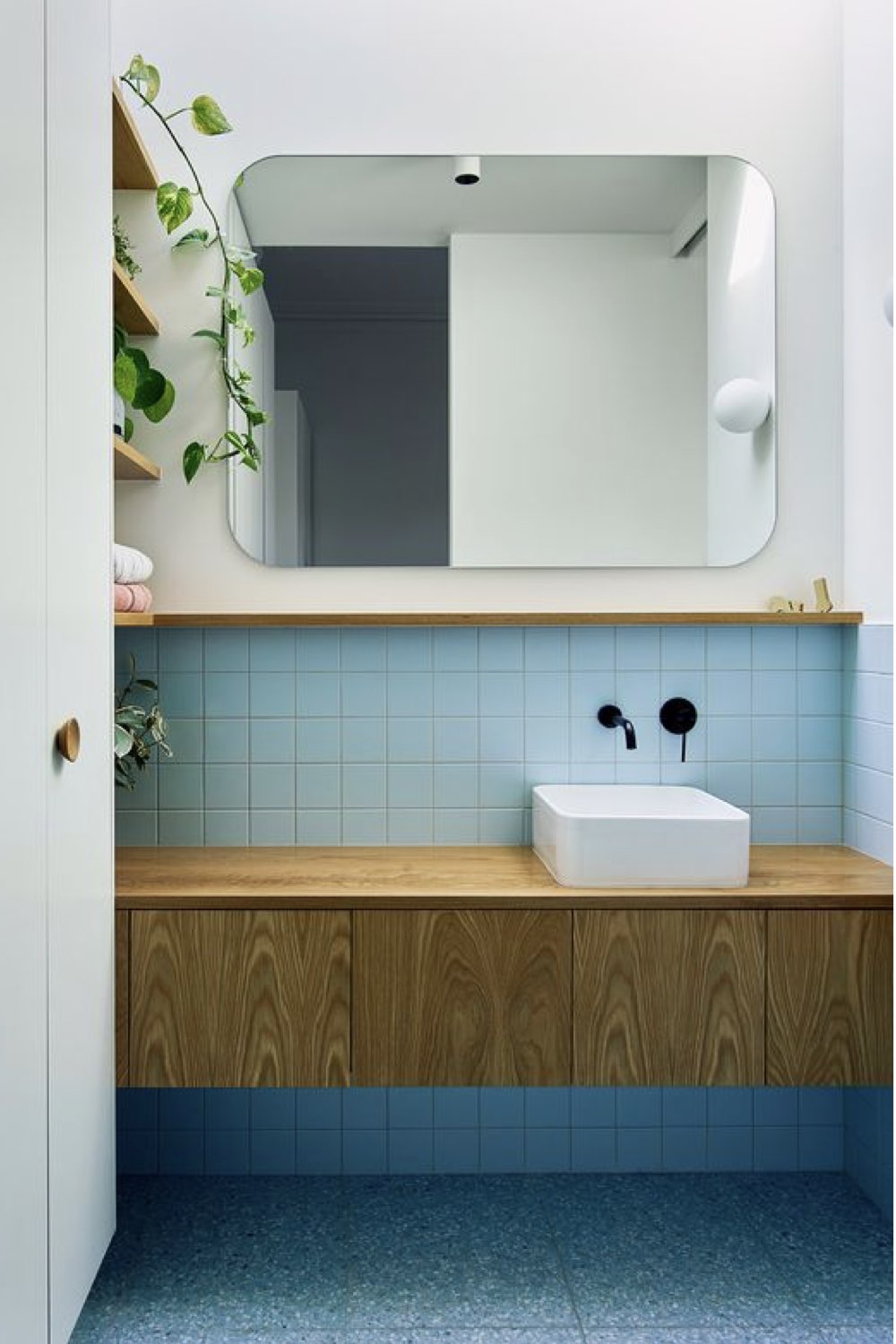 salle de bain decoration reussie exemple vintage minimaliste soubassement carrelage bleu pastel miroir arrondi meuble vasque en bois épuré