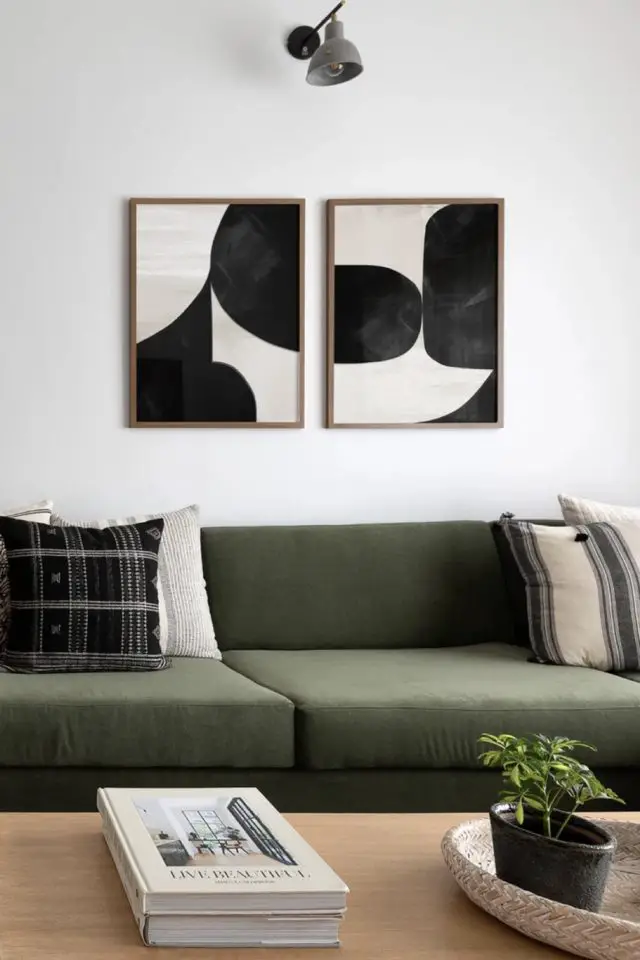 visite deco appartement slow living chic canapé vert kaki moderne tableau poster noir et blanc au dessus coussin neutre table basse en bois