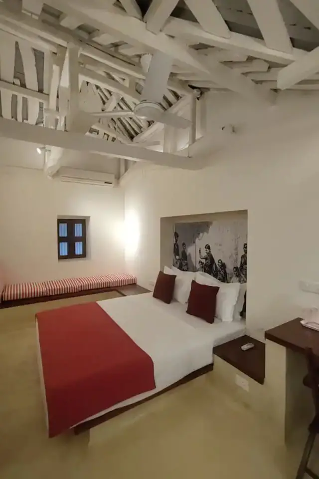 architecture villa traditionnelle tamil nadu inde chambre simple et sobre rouge blanche grise avec banquette rayée