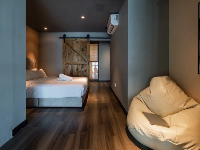 decor loft industriel moderne voyage malaisie chambre à coucher chic et élégante sobre masculine poire pouf beige