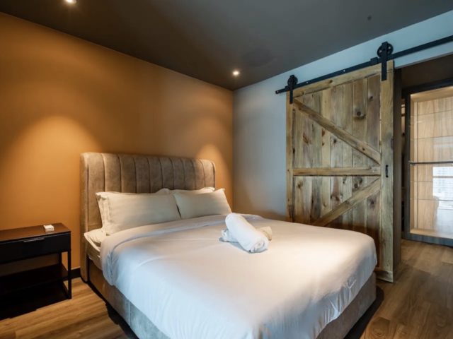 decor loft industriel moderne voyage malaisie chambre à coucher masculine porte coulissante en bois mur accent orange terracotta