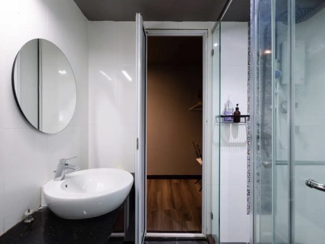 decor loft industriel moderne voyage malaisie salle de douche minimaliste confortable blanche miroir rond au dessus du meuble vasque