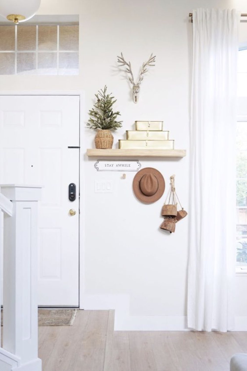 entree maison idee decoration toute petite étagère espace ouvert escalier pièce de vie mur blanc petite boite de rangement chic et simple