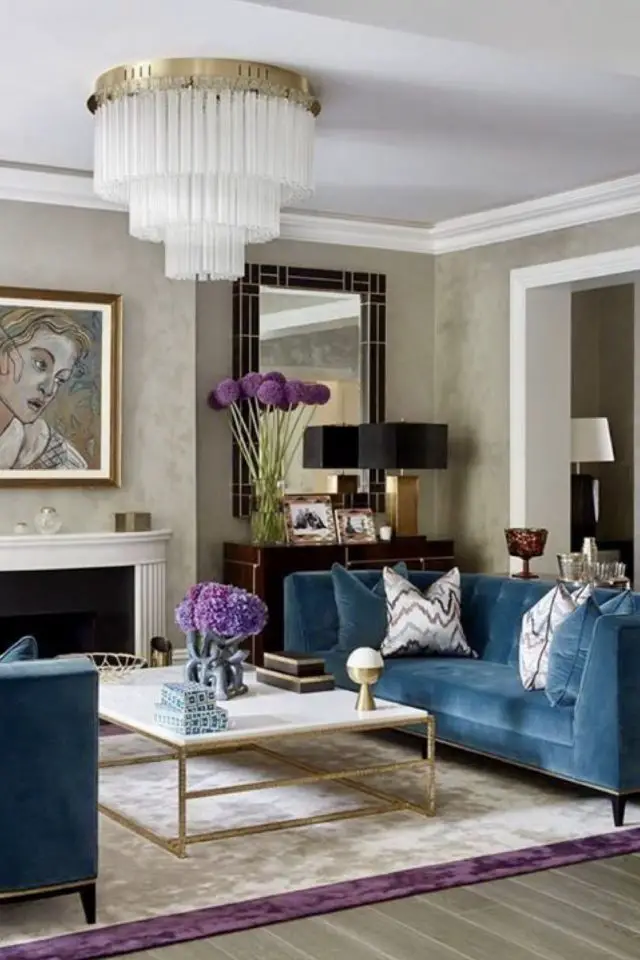 exemple decoration interieur art deco salon couleur neutre canapé bleu en velours luminaire plafond lustre en verre chic élégant rétro