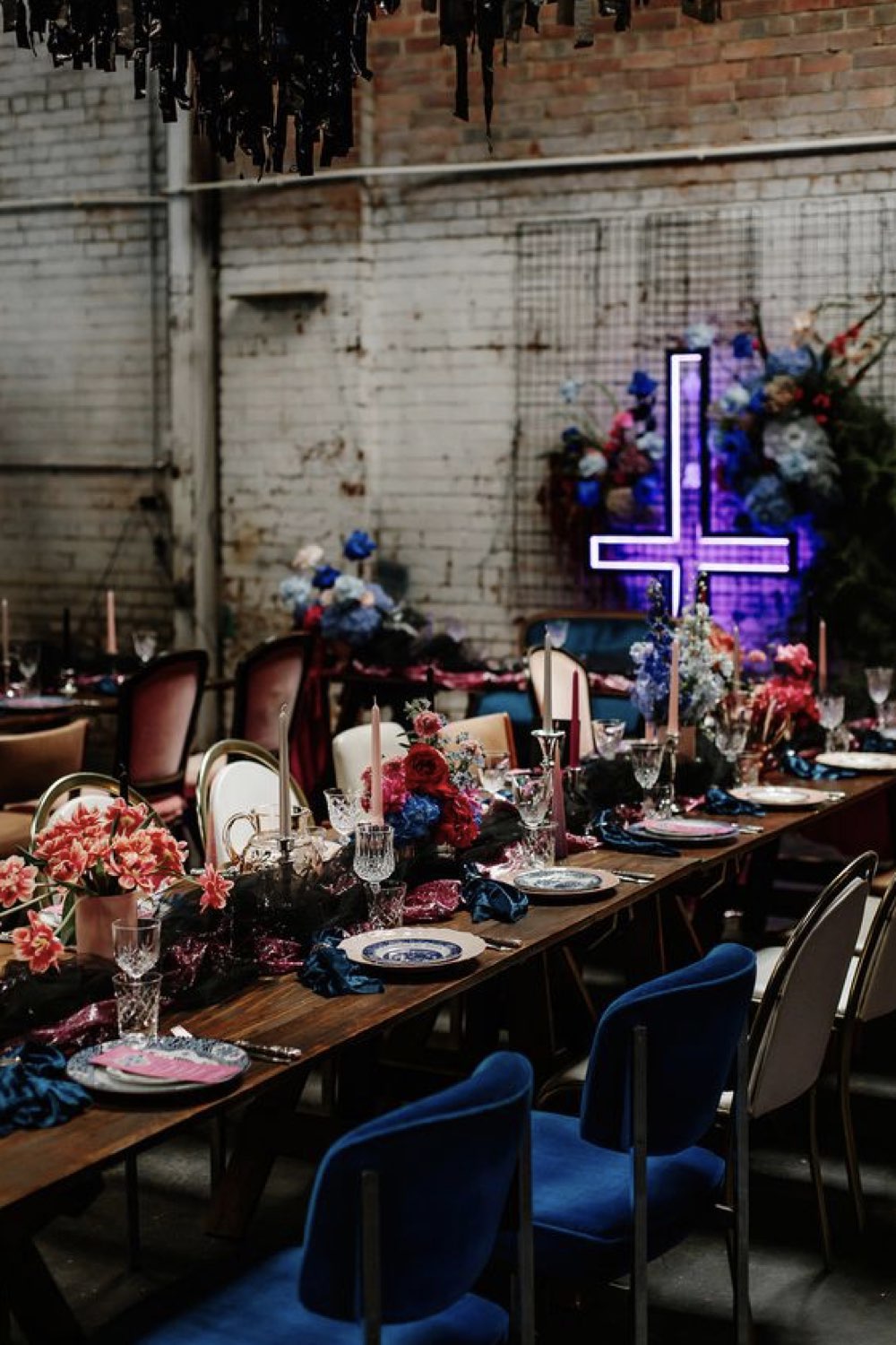 idee mariage theme rock n roll décor de salle grande table nappe sombre bouquet de fleurs croix en néon
