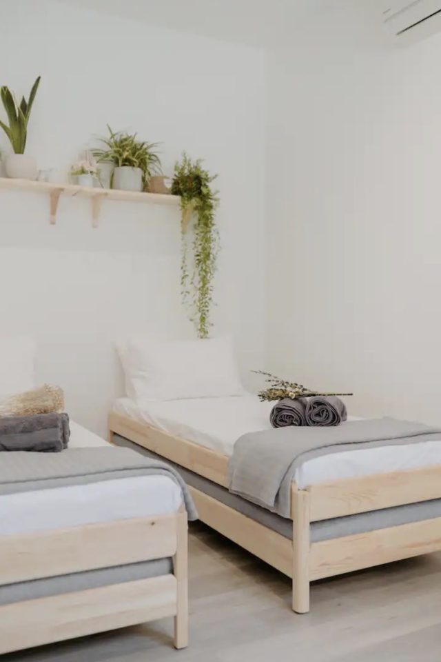 logement deco voyage malaisie chambre lit jumeaux en bois étagère au dessus des lit petite plantes vertes décor moderne et tendance