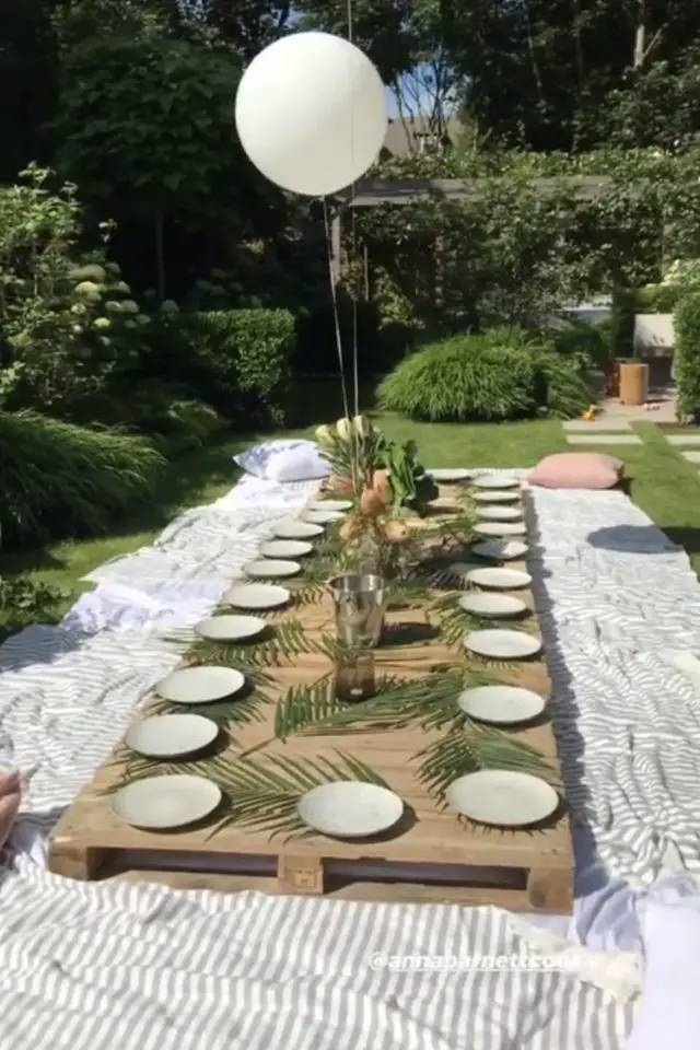 pique-nique deco chic boheme repas en extérieur entre amis récup' palette grand drap blanc feuille de palmier jardin été vacances
