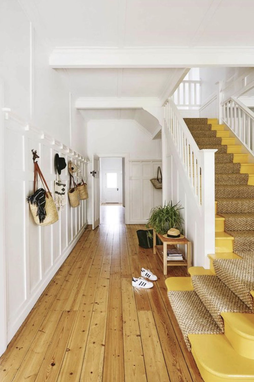 reussir decoration entree idees couloir blanc avec escaliers déco maison touche de couleurs marche revêtement jonc de mer patère murale moulure relief esprit épuré