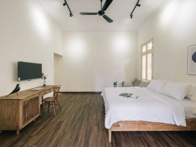 vacances vietnam appartement deco hanoi parquet sombre lit en bois clair ventilateur plafond noir bureau cannage