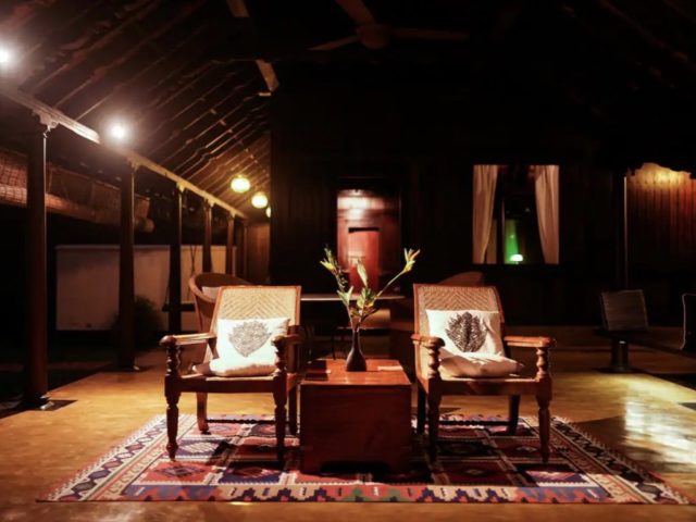 villa exceptionnelle tradition inde du sud salle de séjour style colonial tapis fauteuil ancien en cannage coffre malle table basse