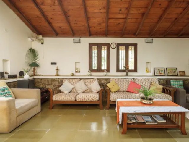 villa familiale moderne et authentique Bangalore grand salon avec canapé vintage en bois et fauteuil