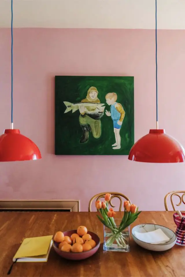 visite deco maison hyper coloree et joyeuse salle à manger grande table en bois suspension vintage luminaire rouge tableau peint à la main