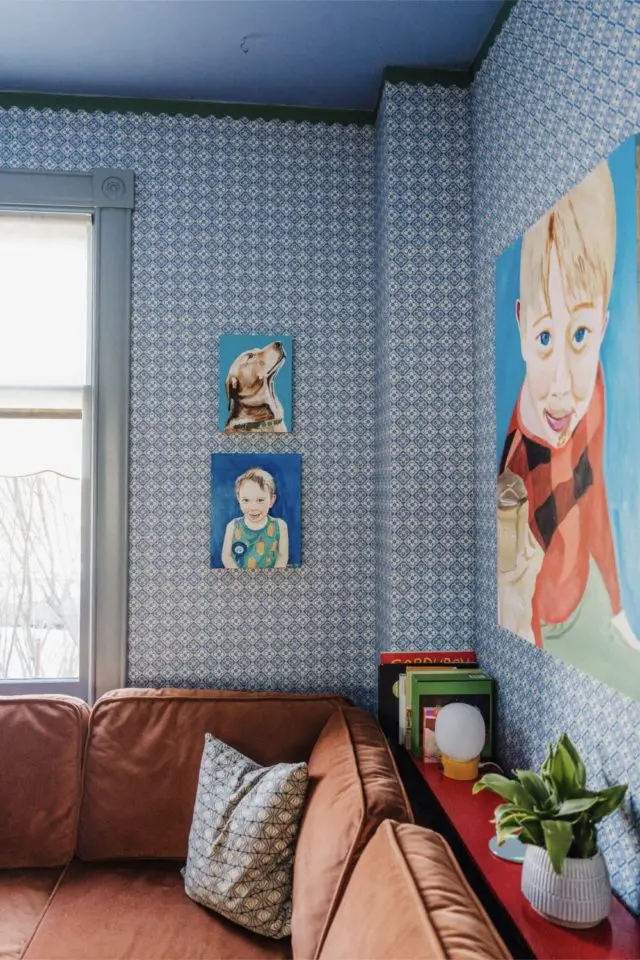 visite deco maison hyper coloree et joyeuse salon original canapé couleur terracotta papier peint bleu à carreaux portrait peint enfant chien