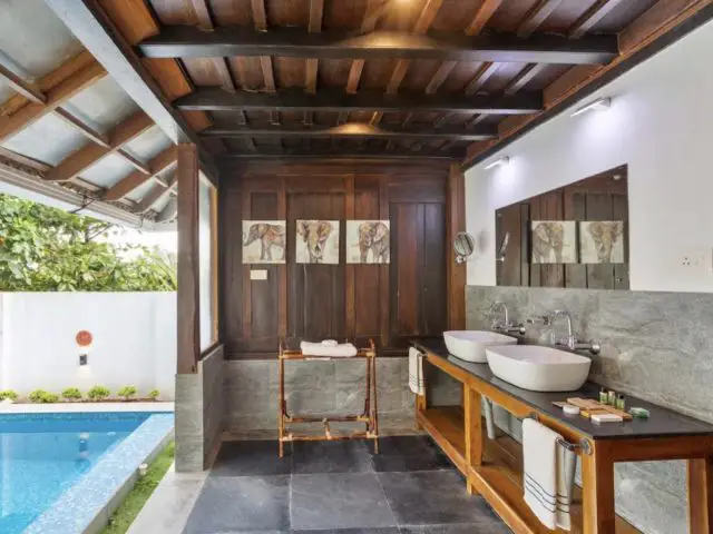 voyage inde kerala hebergement luxe salle de bain meuble double vasque en bois ouverte sur le jardin et la piscine