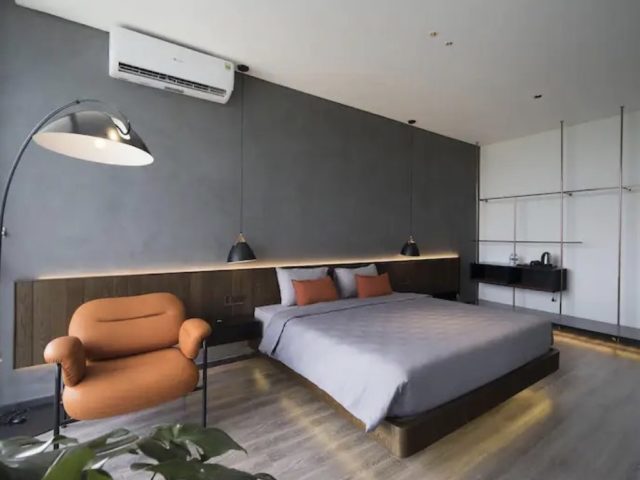 voyager vietnam luxe villa design minimalisme belle chambre à coucher avec tête de lit XXL murale matériaux sobre couleur sourde