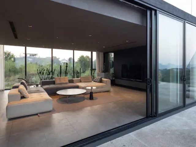 voyager vietnam luxe villa design minimalisme grand salon canapé en U blanc et gris vue sur la piscine baie vitrée