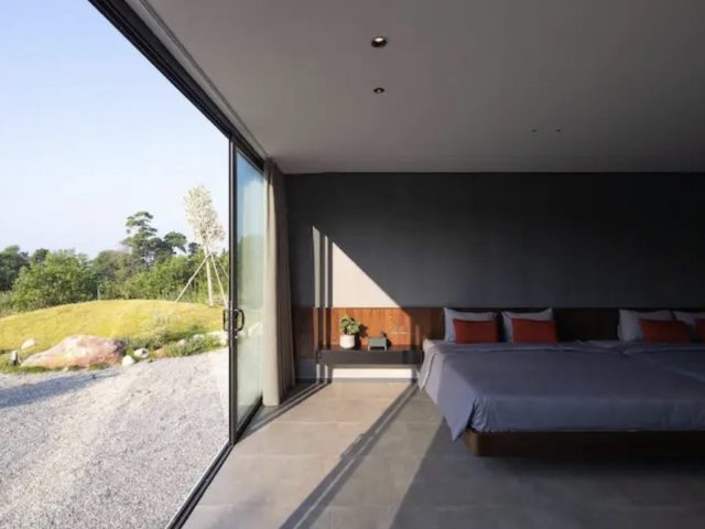 voyager vietnam luxe villa design minimalisme chambre parentale sobre gris noir bois chic baie vitrée soubassement tête de lit