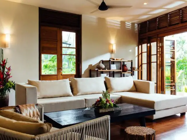 bungalow haut de gamme voyage indonesie espace salon avec grand canapé d'angle décor sobre et chic