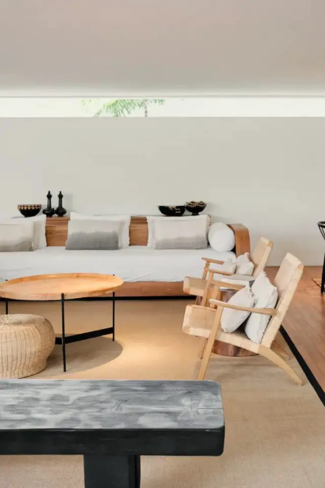 decor voyage asie indonesie grand salon bois et blanc moderne chic tapis en jute meuble en bois table basse ronde petit fauteuil en cannage design