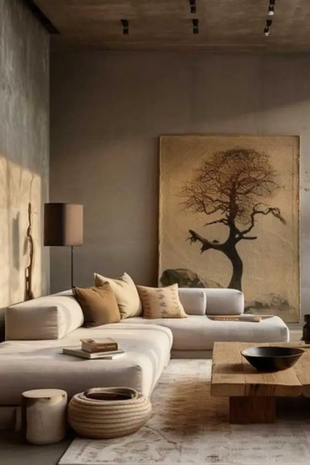 decor wabi sabi caracteristiques salon canapé d'angle couleur écru mur gris clair grand tableau japonais nature arbre table en bois tapis clair
