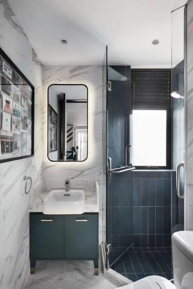 duplex industriel et moderne petite salle de bain d'appoint mur marbre blanc meuble vasque vert émeraude miroir vintage angle arrondi espace douche à l'italienne