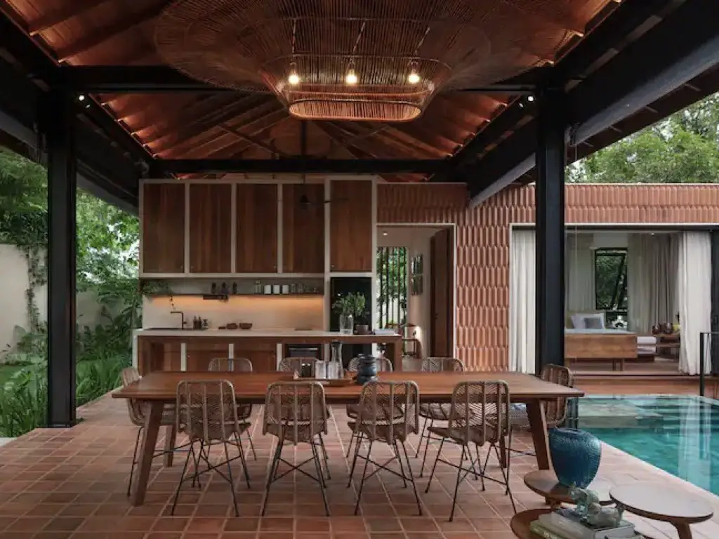 logement vacances luxe sri lanka grande cuisine avec salle à manger partiellement ouvert sur le jardin et la piscine mobilier en bois simple et chic