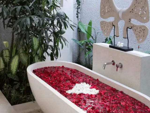 vacances indonesie hebergement exception luxe salle de bain luxueuse baignoire îlot romantique pétale de rose plantes vertes