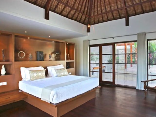 vacances indonesie hebergement exception luxe chambre à coucher suite parentale tête de lit bois avec niche et objets décoratifs baie vitrée