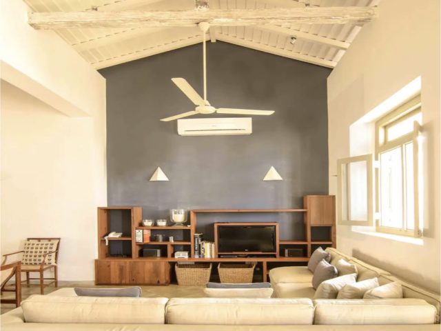 voyage haut de gamme sri lanka hebergement unique grand espace de vie canapé d'angle beige mur accent peinture grise foncée meuble en bois foncé