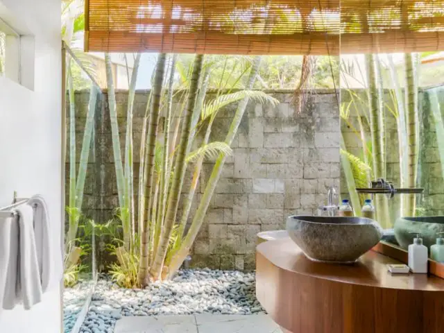voyage indonesie bali hebergement luxe salle de bain esprit tropical mur en béton plantes extérieures meuble vasque en bois et pierre