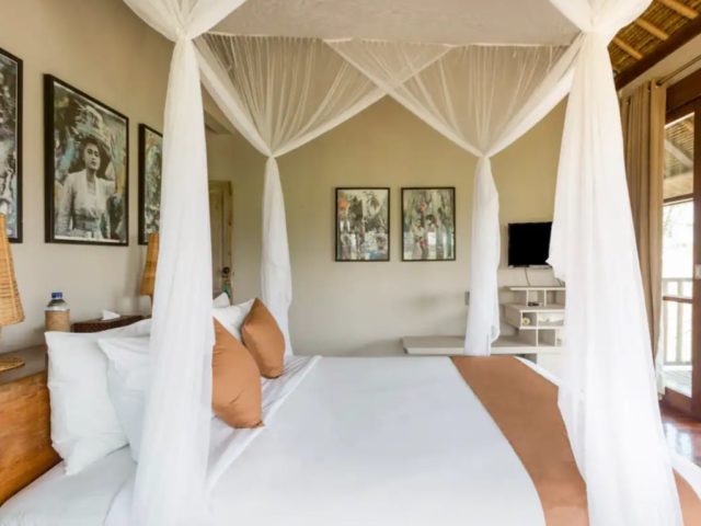 voyage indonesie bali hebergement luxe décor de chambre à coucher esprit colonial lit à baldaquin photographie en noir et blanc déco murale