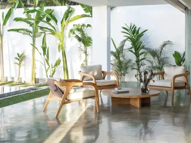voyage sri lanka hebergement dexception petit salon terrasse couverte fauteuil chic en bois table basse ronde plantes tropicales et piscine